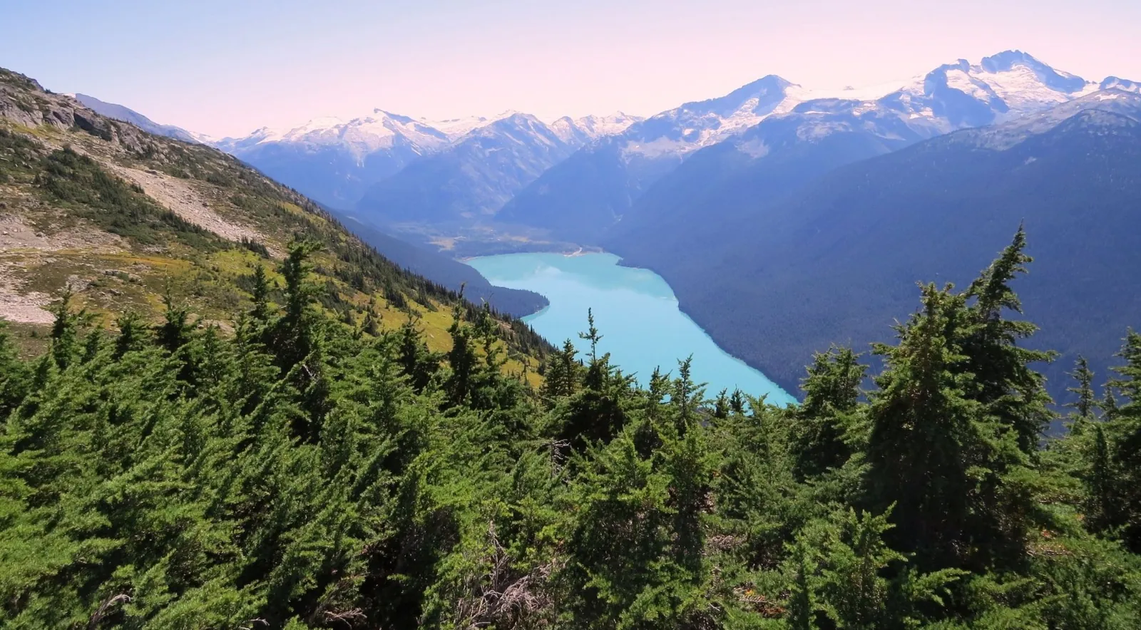 Snow-capped Coast Mountains above a turquoise glacial lake in the Whistler backcountry
