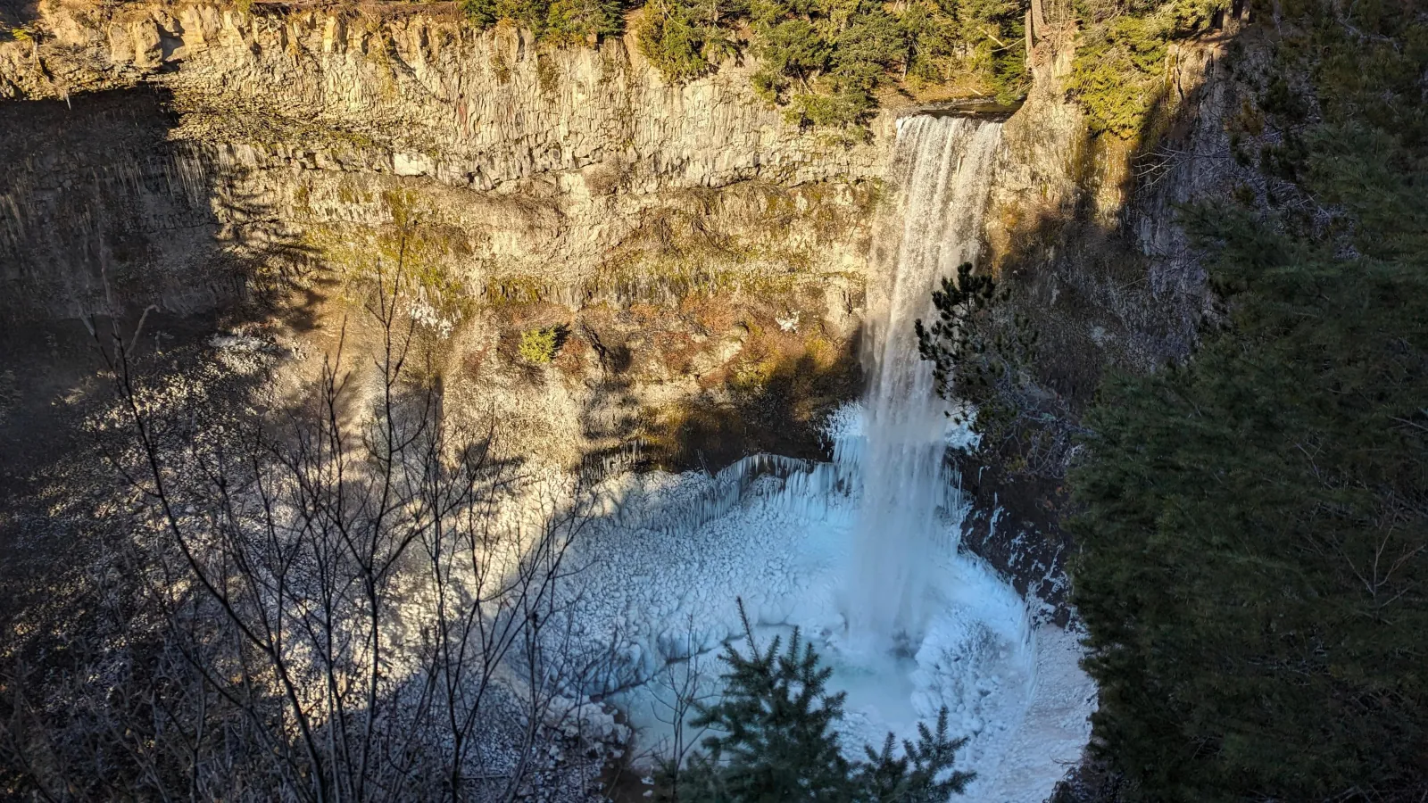 Brandywine Falls dropping into an ice-rimmed volcanic canyon in winter sun