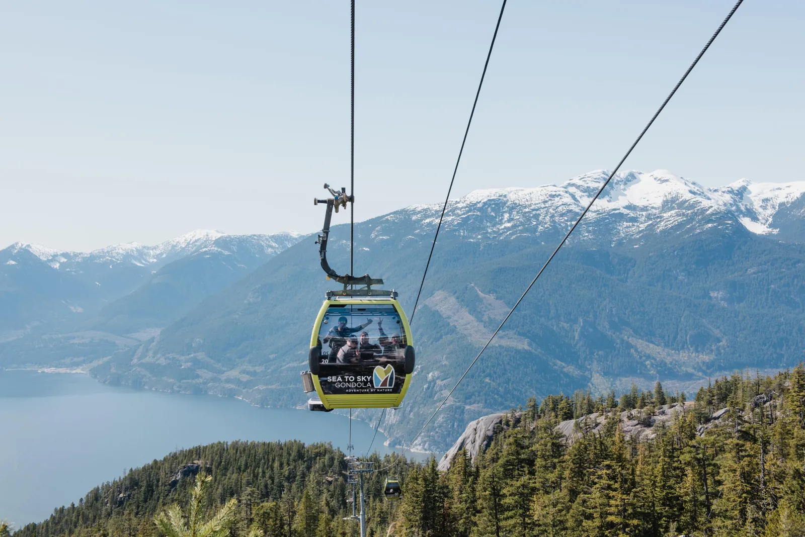 Sea to Sky Gondola cabin on its cable above forest and Howe Sound