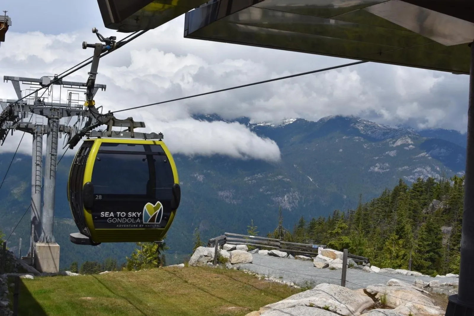 Sea to Sky Gondola cabin arriving at the summit station with clouds over the Coast Mountains