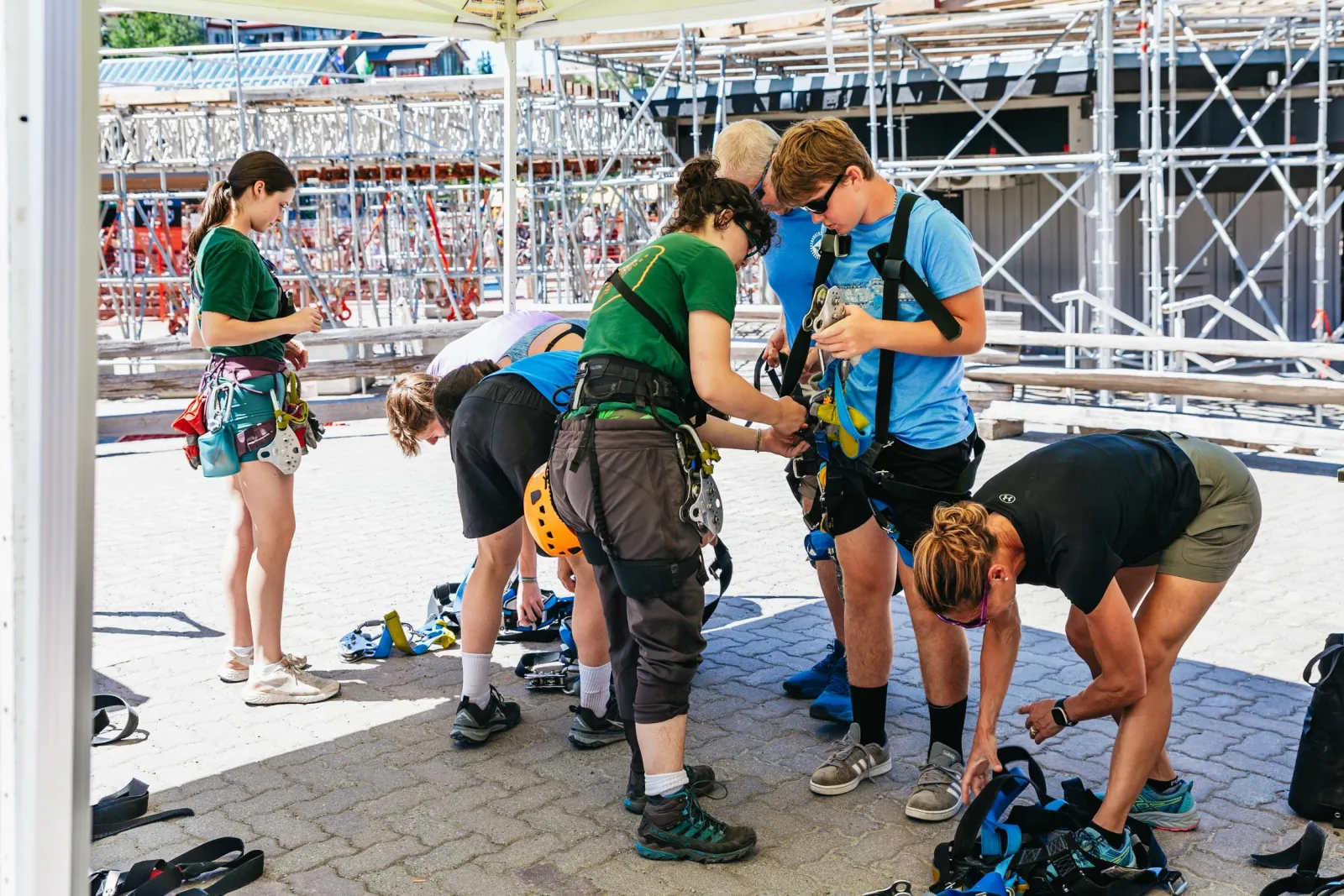 Guides helping guests into harnesses at the gear-up area in Whistler Village